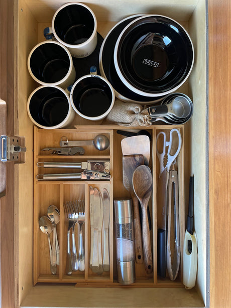 RV rental kitchen drawer: efficiently organized with mugs, bowls, cooking utensils, and silverware for your journey.