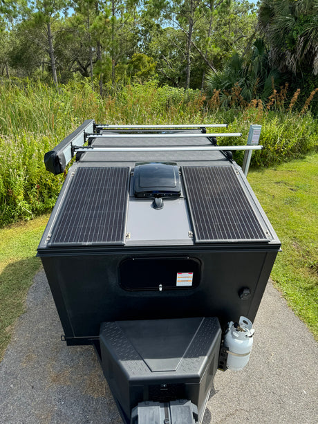 Top-down view of an RV rental trailer with solar panels, ready for off-grid camping and nature adventure.