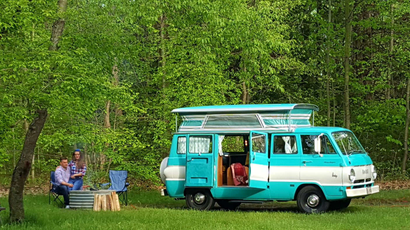 This charming aqua and white vintage pop-top rv rental van is perfect for a peaceful camping getaway with a campfire.