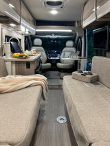 Step inside this modern rv rental with facing couches, a well-equipped kitchen, and the cockpit for a comfortable journey.