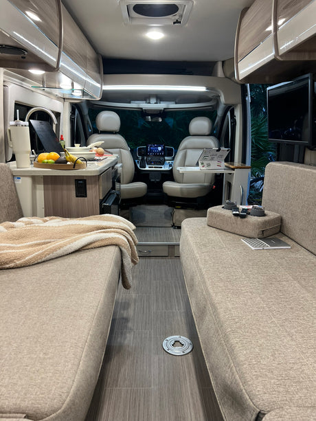 Step inside this modern rv rental with facing couches, a well-equipped kitchen, and the cockpit for a comfortable journey.