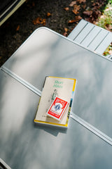 RV rental trip essentials: "Short Hikes" guide and playing cards ready on a camp table for outdoor adventure.