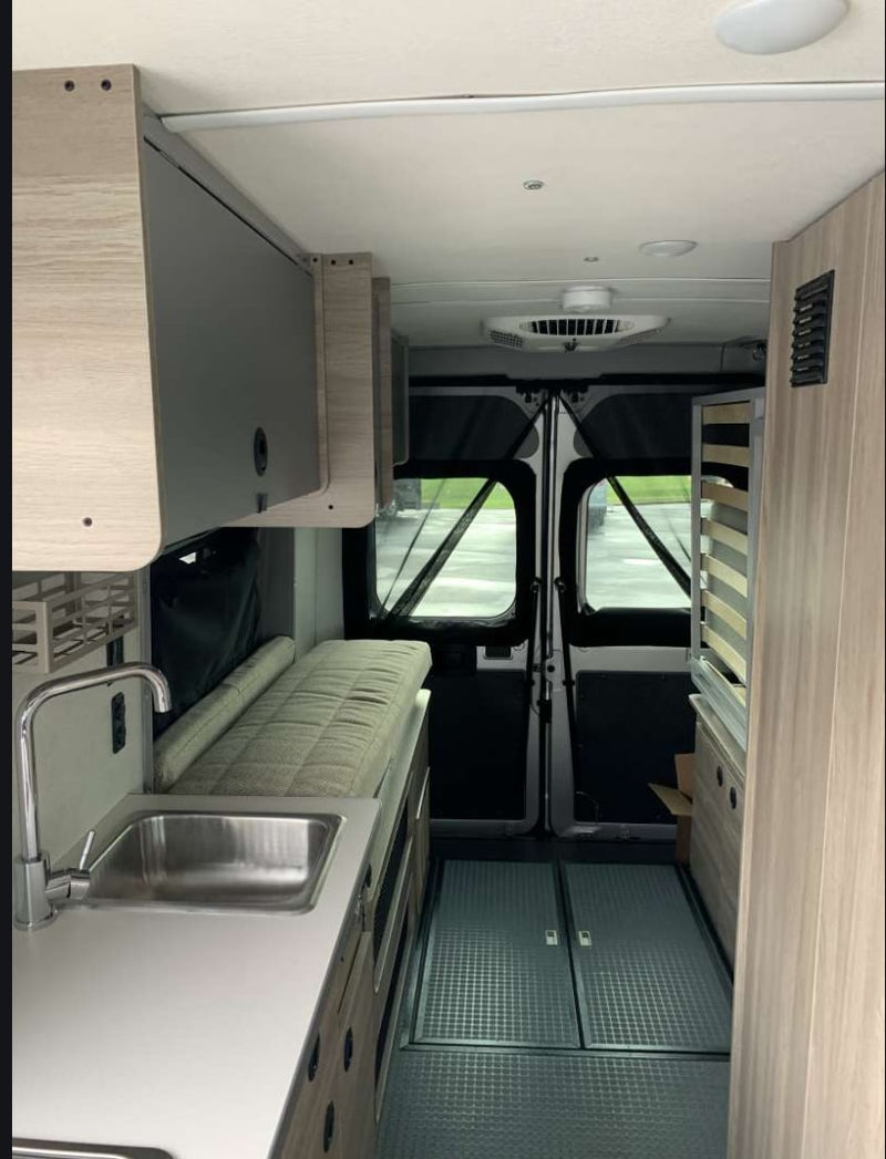  and textured countertop with wood-grain cabinets. Scenic views outside.|Inside this RV rental: a modern kitchen with sink — photo 5