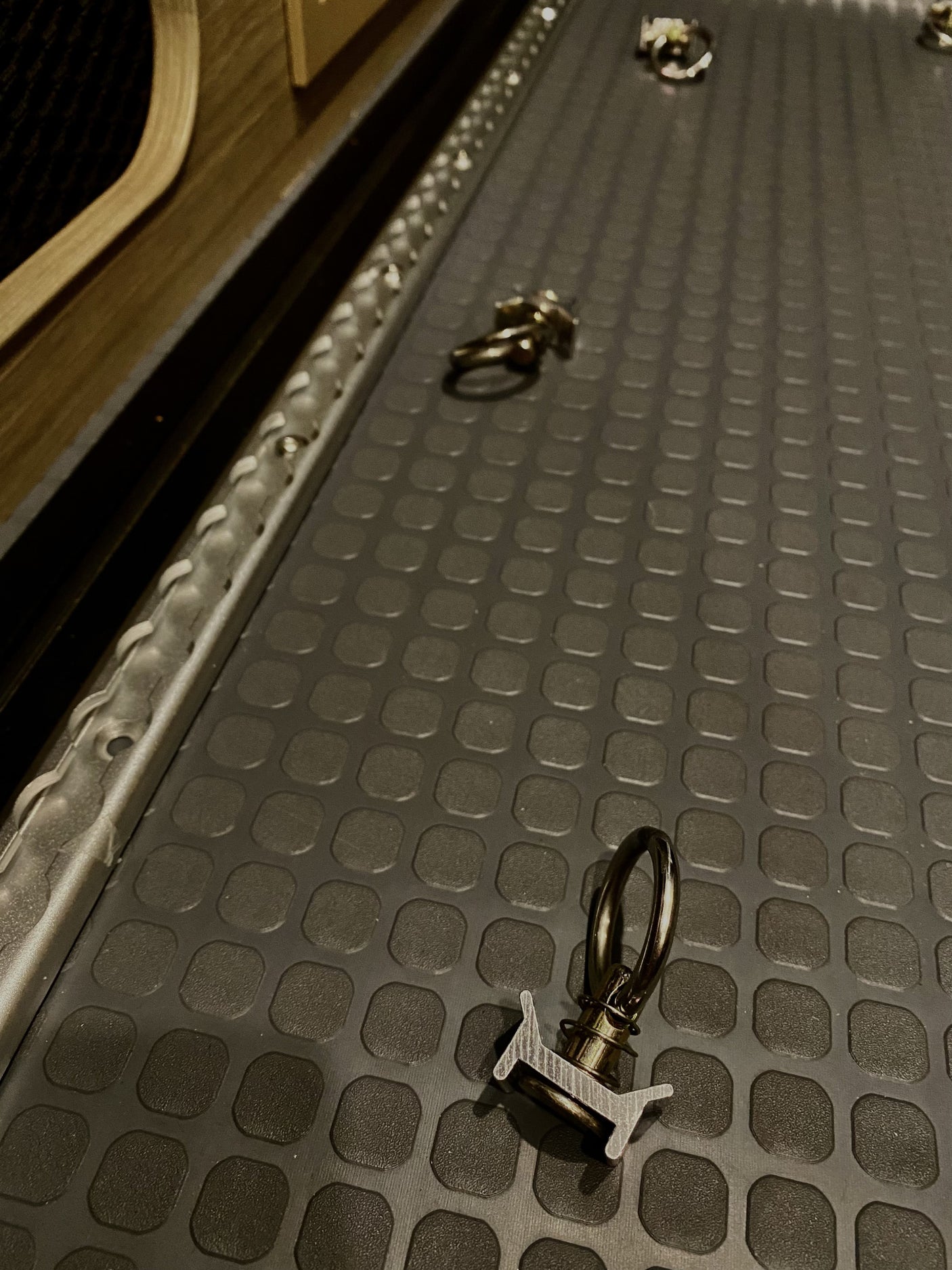 RV rental cargo area with L-track single stud tie-downs & textured floor mat for securing your gear.