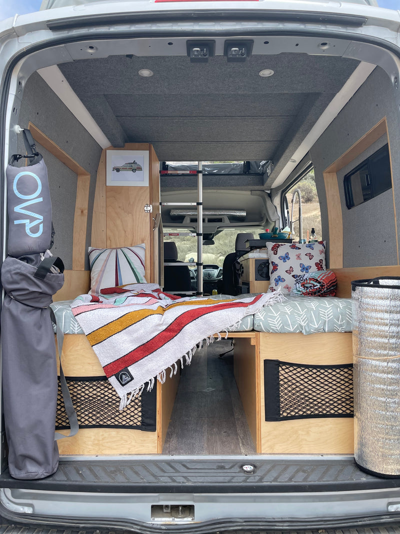 Cozy camper van interior: bed, storage, & kitchen area, ready for an RV rental adventure. — photo 4