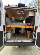Explore comfort in this custom camper van rv rental! Features elevated bed, wooden interior, and smart storage.