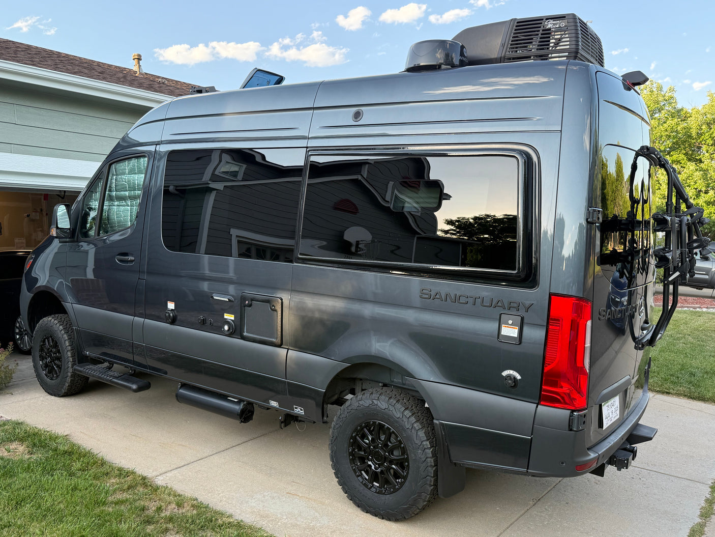 Gray Sanctuary rv rental camper van, a Mercedes-Benz Sprinter conversion, with bike rack & utility hookups.