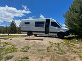 White camper van parked at a mountain campsite with a dog. Ideal for your next rv rental adventure.