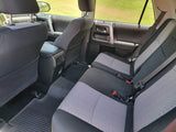 Vehicle's clean rear interior: gray striped seats, rubber floor mats with Toyota logo. Great for an RV rental experience.