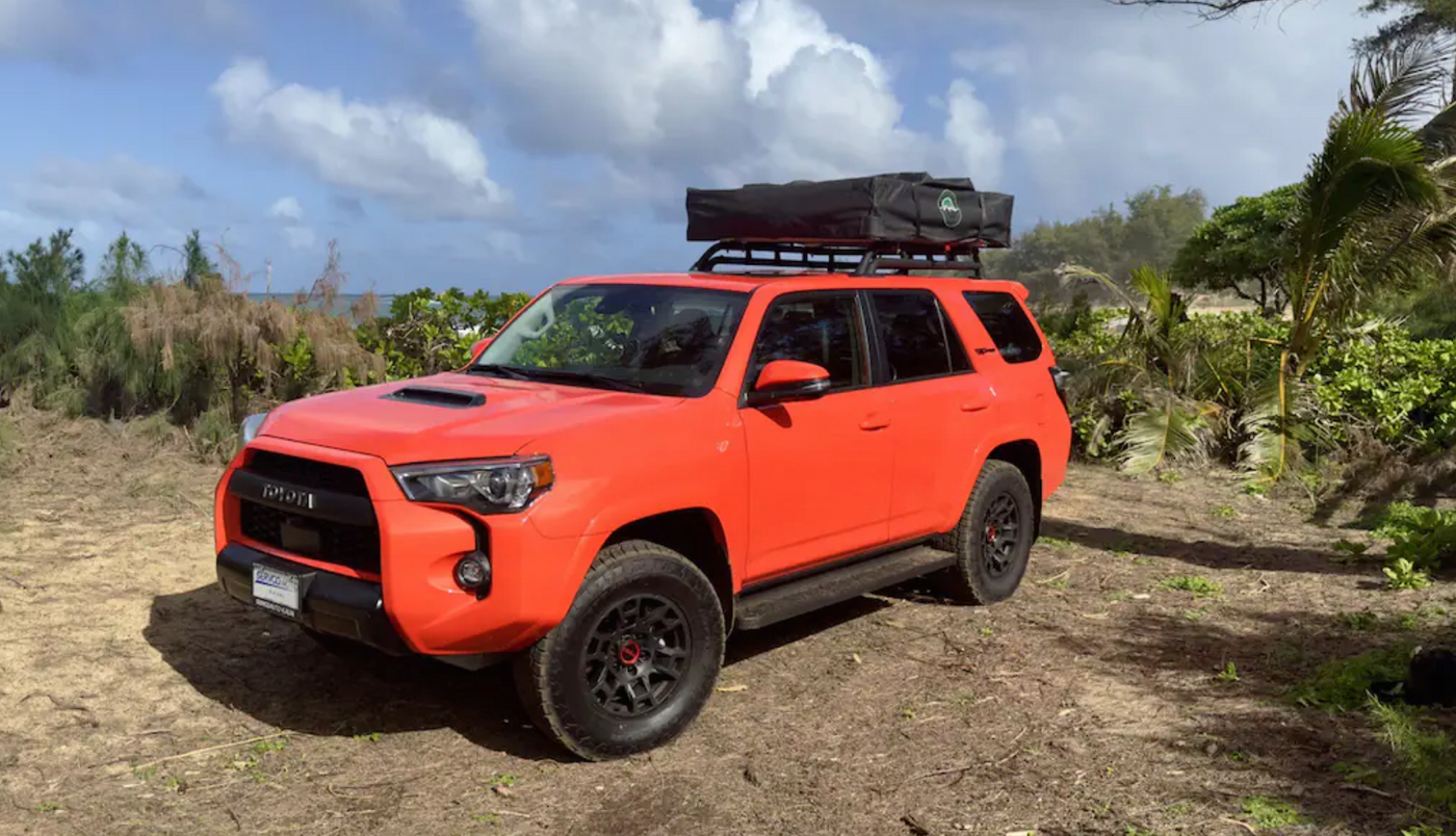 Bright orange Toyota 4Runner with a rooftop tent, an ideal RV rental for coastal adventures. — photo 9