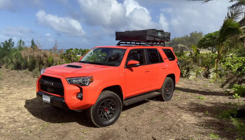 Bright orange Toyota 4Runner with a rooftop tent, an ideal RV rental for coastal adventures. — photo 9