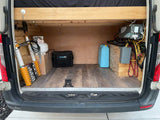 Explore the organized cargo space of an RV rental: propane tank, portable shower, telescoping ladder, battery power system, and water storage.