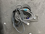 Braided USB-C & Lightning cable atop an RV rental's power monitor showing 12.7V. Essential for your journey.
