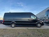 Black luxury coach van, ideal for RV rental, with "ULTIMATE COACH" branding visible on its side, parked outdoors.