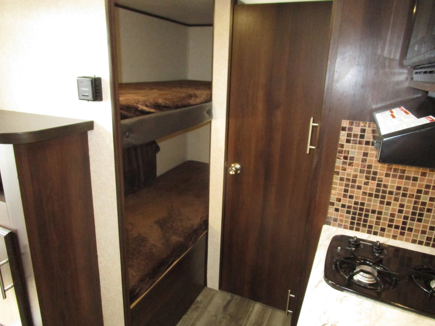  and fridge. Compact design with tiled backsplash.|This RV rental offers a spacious dinette with a central table — photo 9