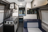 Bright rv rental interior with kitchen sink, fridge, control panel, and rear bed. Modern camper van layout.