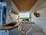 Spacious RV rental interior with modern kitchen, comfy bed, and open views. Perfect for adventure travel.