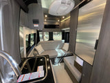 Bright, modern rv rental interior with kitchen, comfy sofa, fridge, and large windows. Enjoy scenic camper van travel!