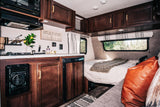 Cozy RV rental interior with a compact kitchen, comfy bed, and inviting lounge area for your adventures.
