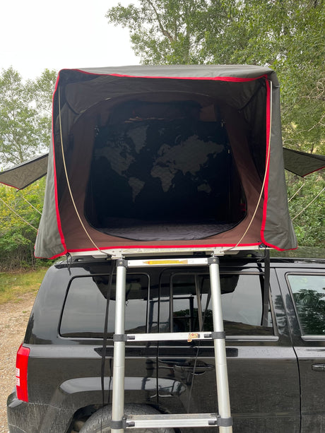  a world map design awaits for your next car camping trip.|Black SUV with iKamper roof-top tent set up for camping. Great rv rental alternative for outdoor adventures.