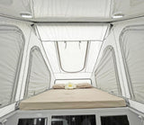 Cozy interior of a rooftop tent with a comfy bed, perfect for your RV rental adventure. Lights & windows visible.