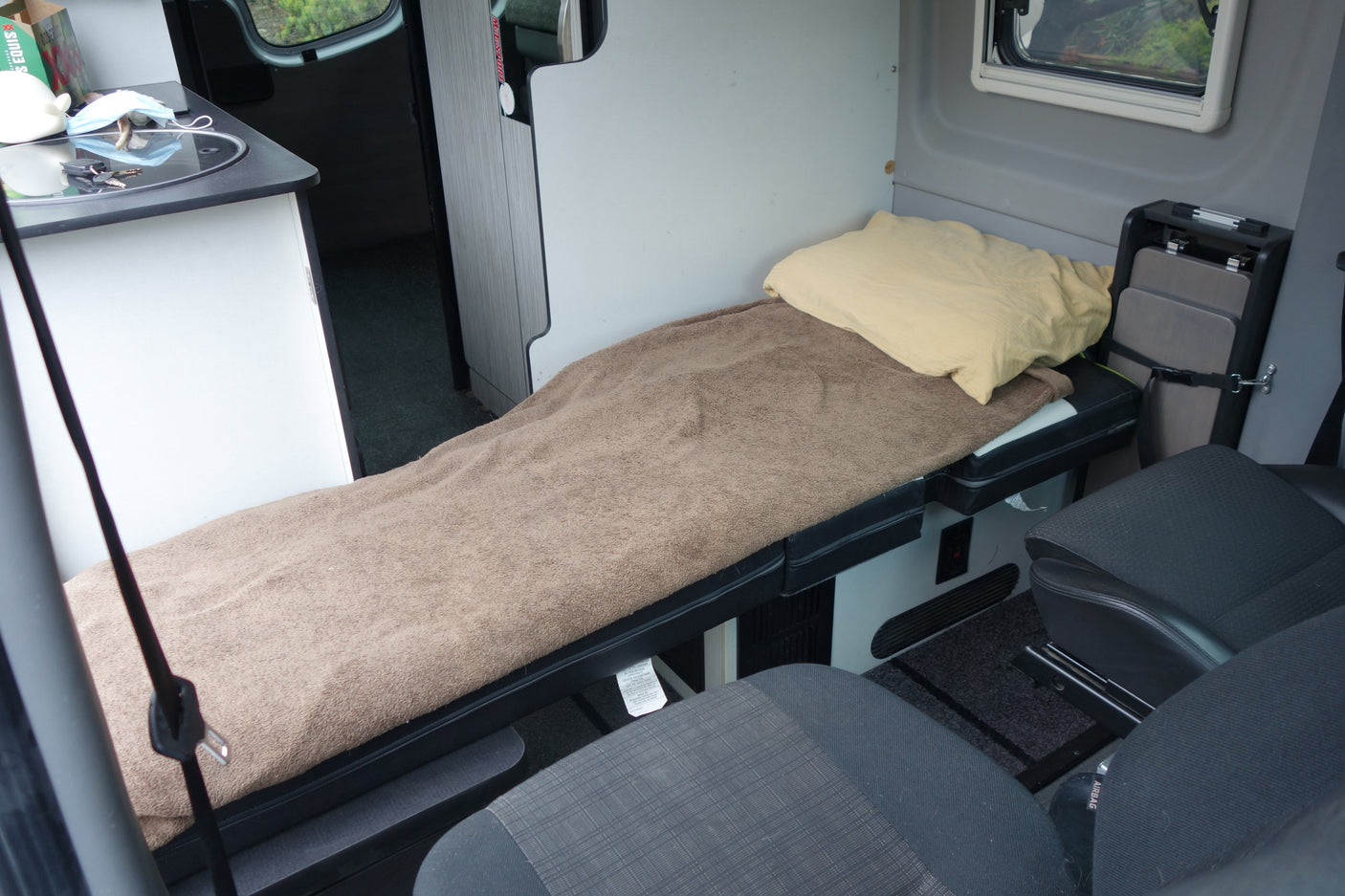 Cozy rv rental interior: compact sleeping area, kitchenette, and portable table for a comfortable road trip.