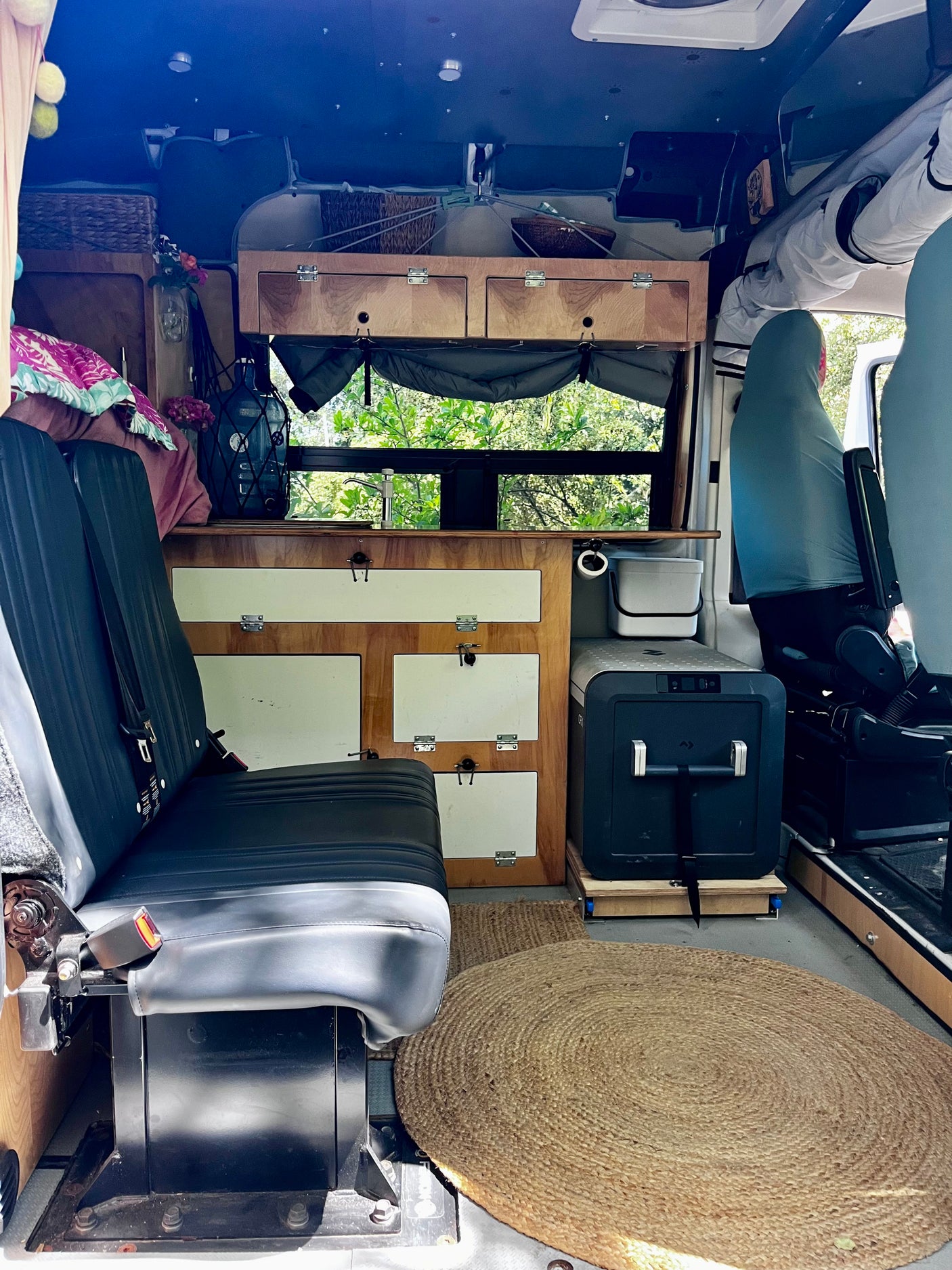 RV rental interior showcasing a compact kitchen, seating, and storage for comfortable vanlife adventures.