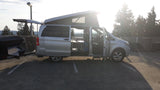 Silver Mercedes Metris pop-top camper van RV rental, open and ready for adventure with its rear trailer.