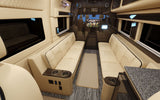 Inside a premium rv rental: plush cream seating, wood floors, and entertainment screen for ultimate comfort on the go.