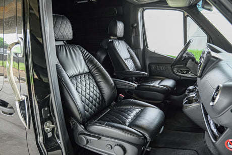 Luxurious black leather interior of a custom van, featuring quilted seats and modern dashboard, ideal for rv rental or executive travel.