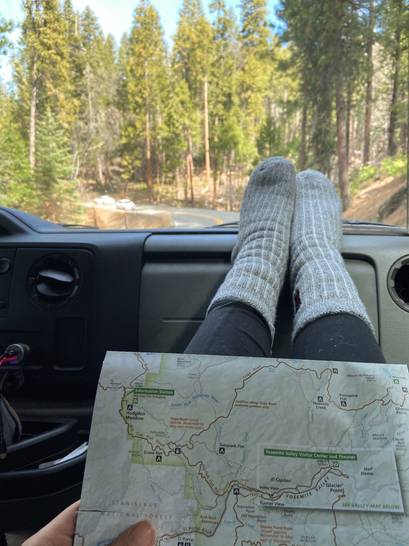 RV rental road trip: Feet up, map open, exploring Yosemite National Park's scenic roads.