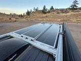 Rooftop solar panels on an rv rental van, showcasing renewable energy for off-grid adventures in a scenic, hilly landscape.