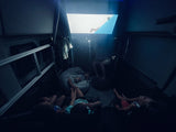 Fun family movie night inside an RV rental! Kids are cozy, watching an animated film projected on the wall.