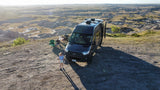 Experience stunning views with an RV rental! This camper van is parked overlooking badlands, with a child enjoying the vast landscape.