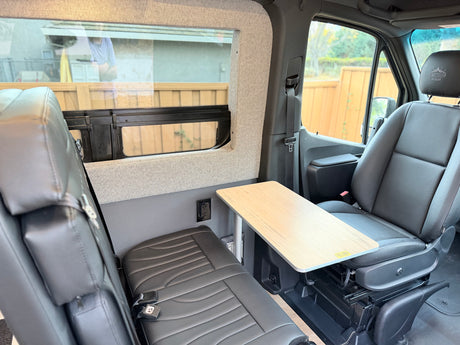 Interior of an RV rental: a flexible dinette with a swivel seat, bench, table, and power outlet for convenience.