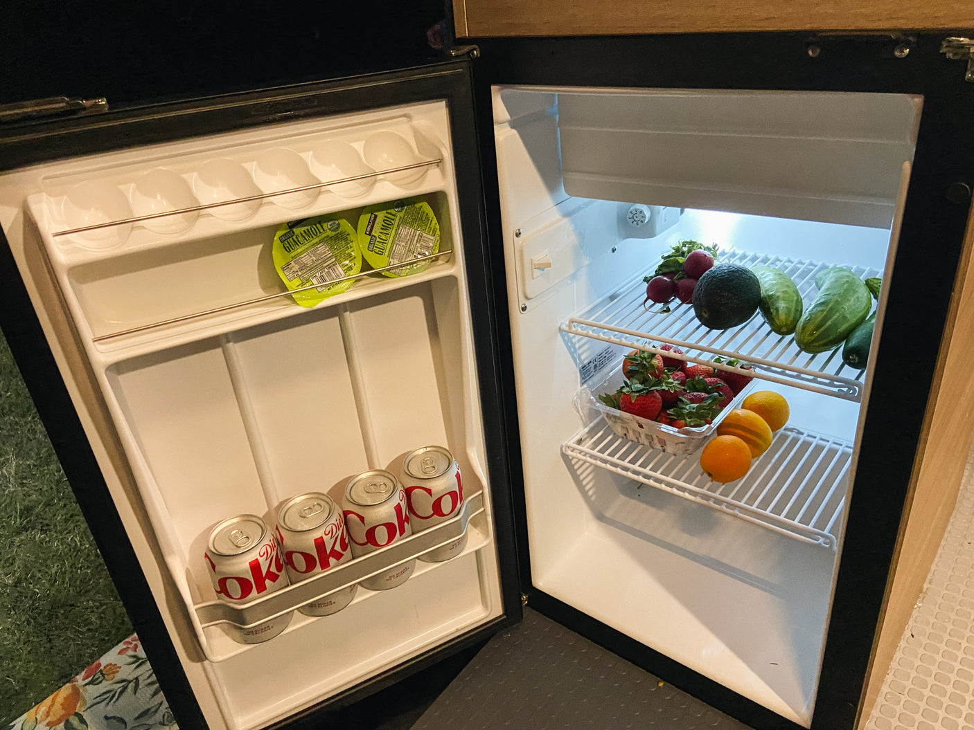 Open RV rental fridge with fresh fruit, veggies, guacamole, and Diet Coke. Everything you need for the road!