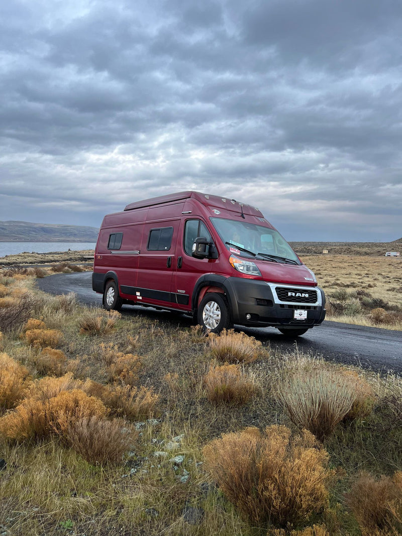  offering panoramic views of a wide river valley and mountains.|Woman inside a red Winnebago Solis RV rental camper van — photo 4