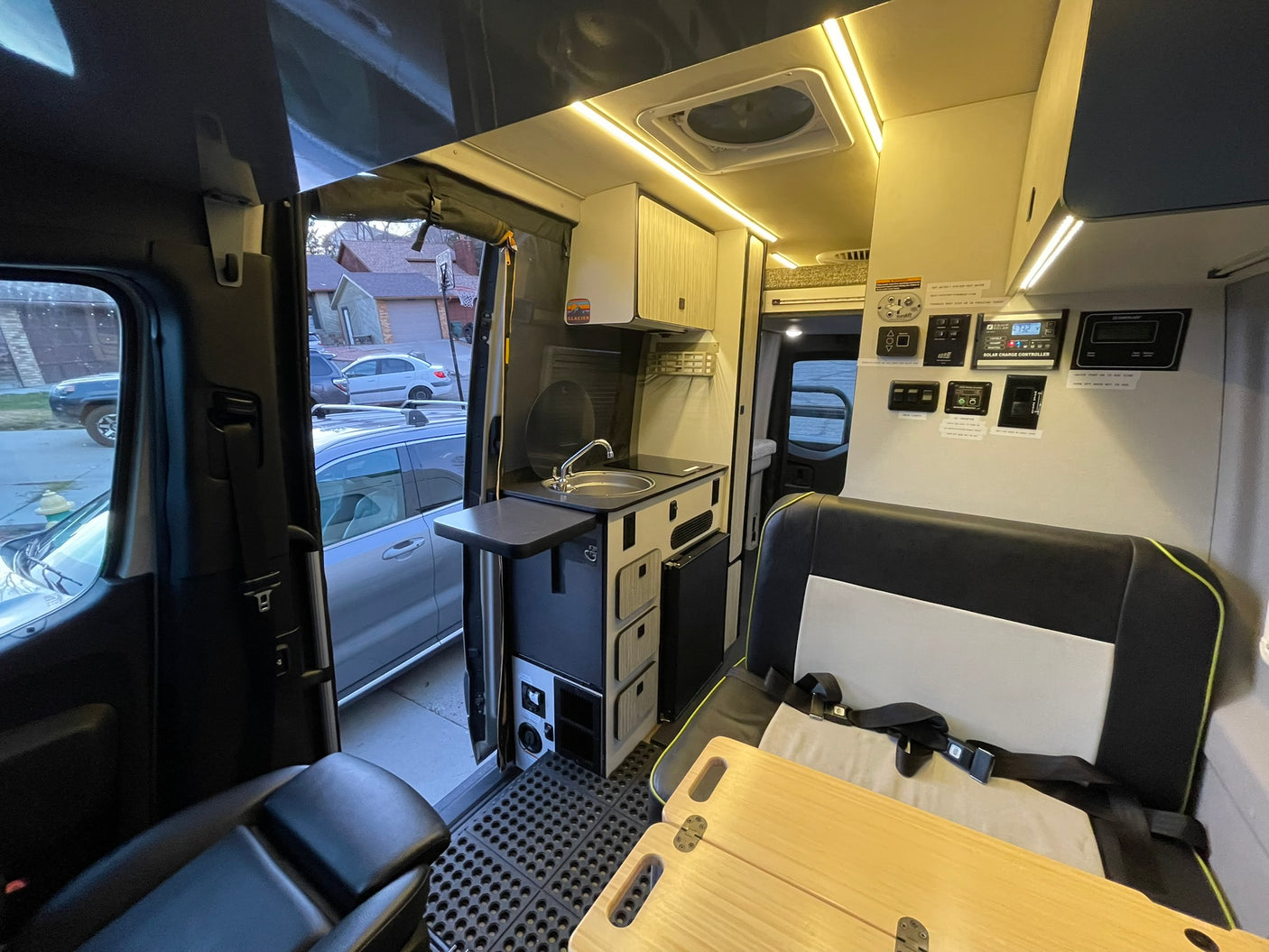 Inside a modern rv rental camper van: kitchen, seating, overhead lighting, and control panels. Ready for adventure!