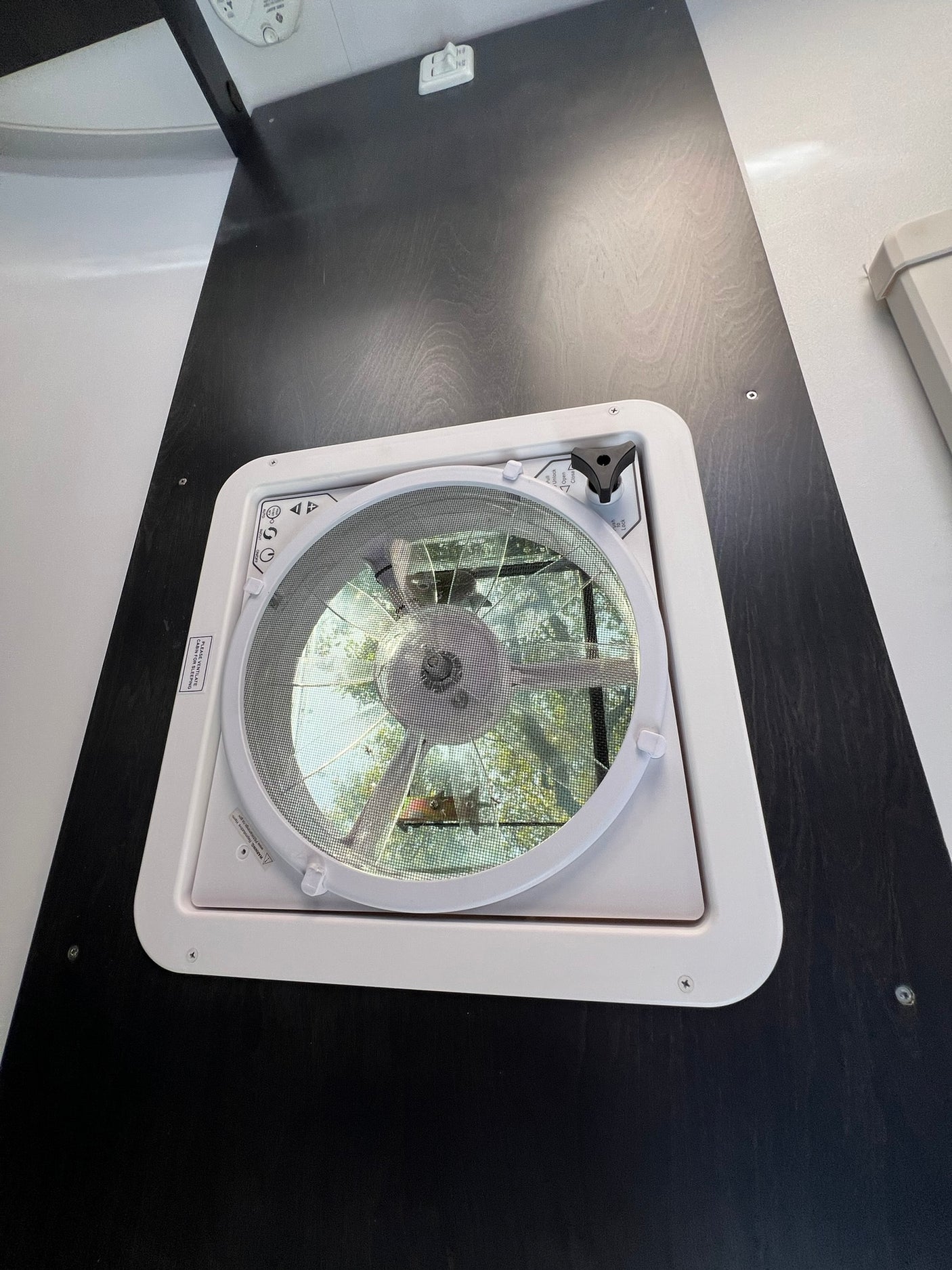 This RV rental's ceiling fan and vent offers fresh air, natural light, and outdoor views for comfort.