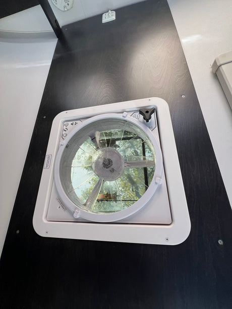 This RV rental's ceiling fan and vent offers fresh air, natural light, and outdoor views for comfort.