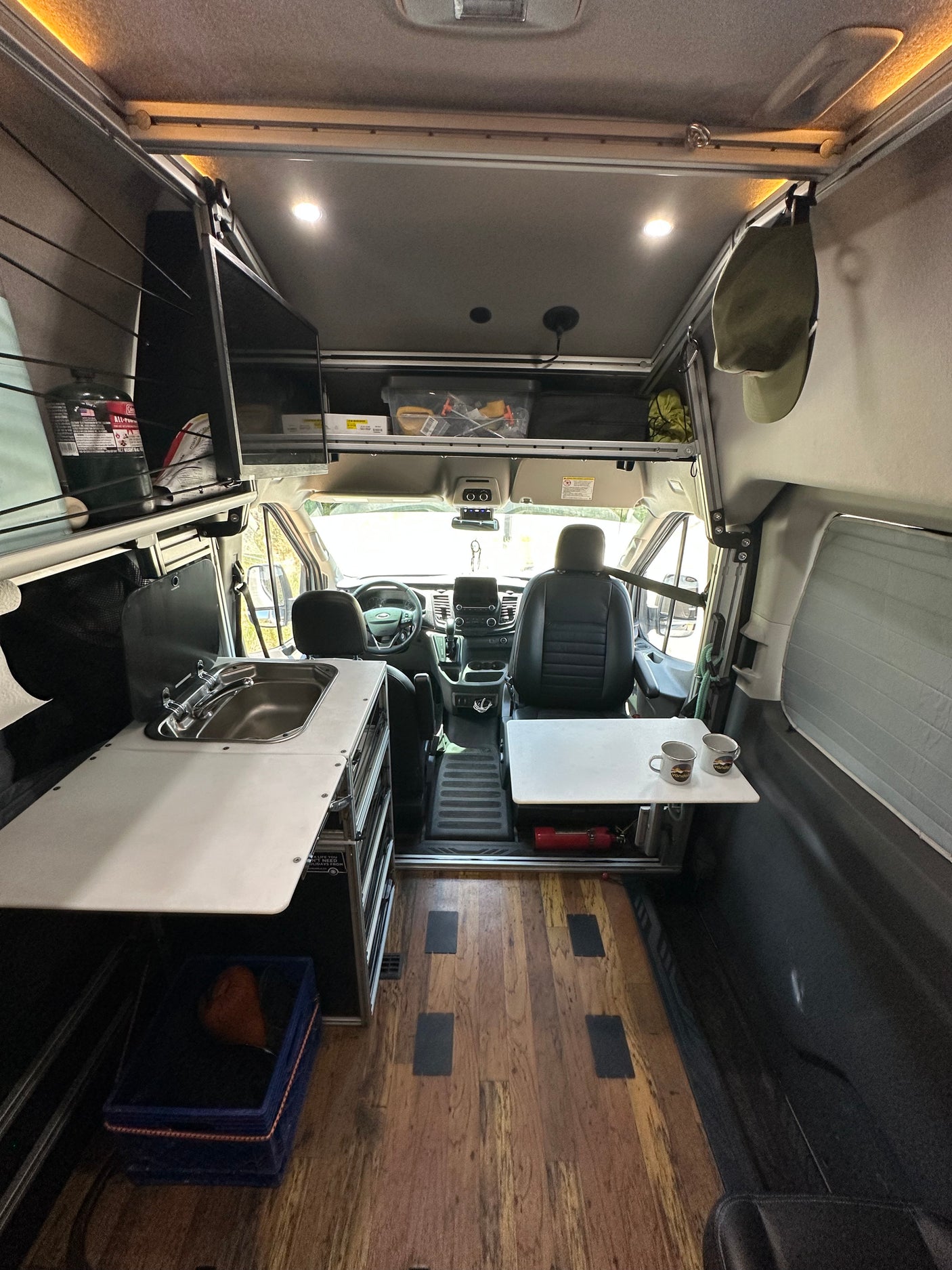 Inside a modern rv rental camper van, showing the compact kitchen with sink, seating area, and cockpit. Perfect for road trips.