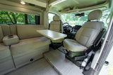 Spacious RV rental interior featuring a dinette with sofa seating and swiveling front seats.