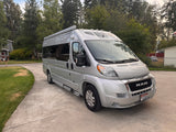 Silver Roadtrek Ram ProMaster rv rental van on a driveway. Perfect camper for adventurous travel.