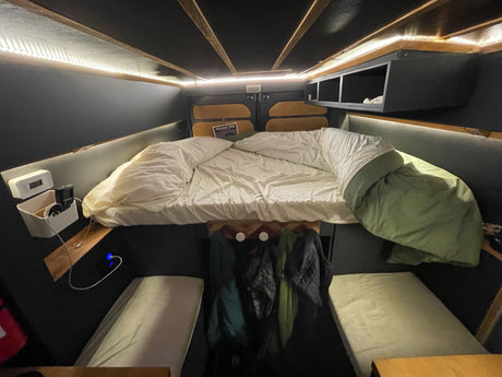 RV rental's cozy interior: a large main bed, bright LED lighting, and lower sleeping/seating areas make for comfortable travel.