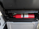 An essential safety item in an RV rental: a red fire extinguisher securely mounted above a Dometic fridge/cooler.