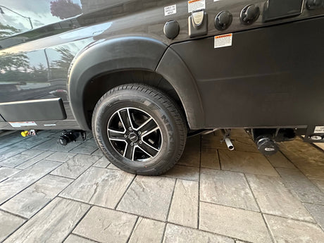 Side view of an RV rental's rear wheel with Nexen tire and Fast wheel, plus essential utility hookups for cable/satellite & power.