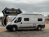 Family road trip fun! Dad & kids in an RV rental at the famous Route 66 Kingman, Arizona sign.