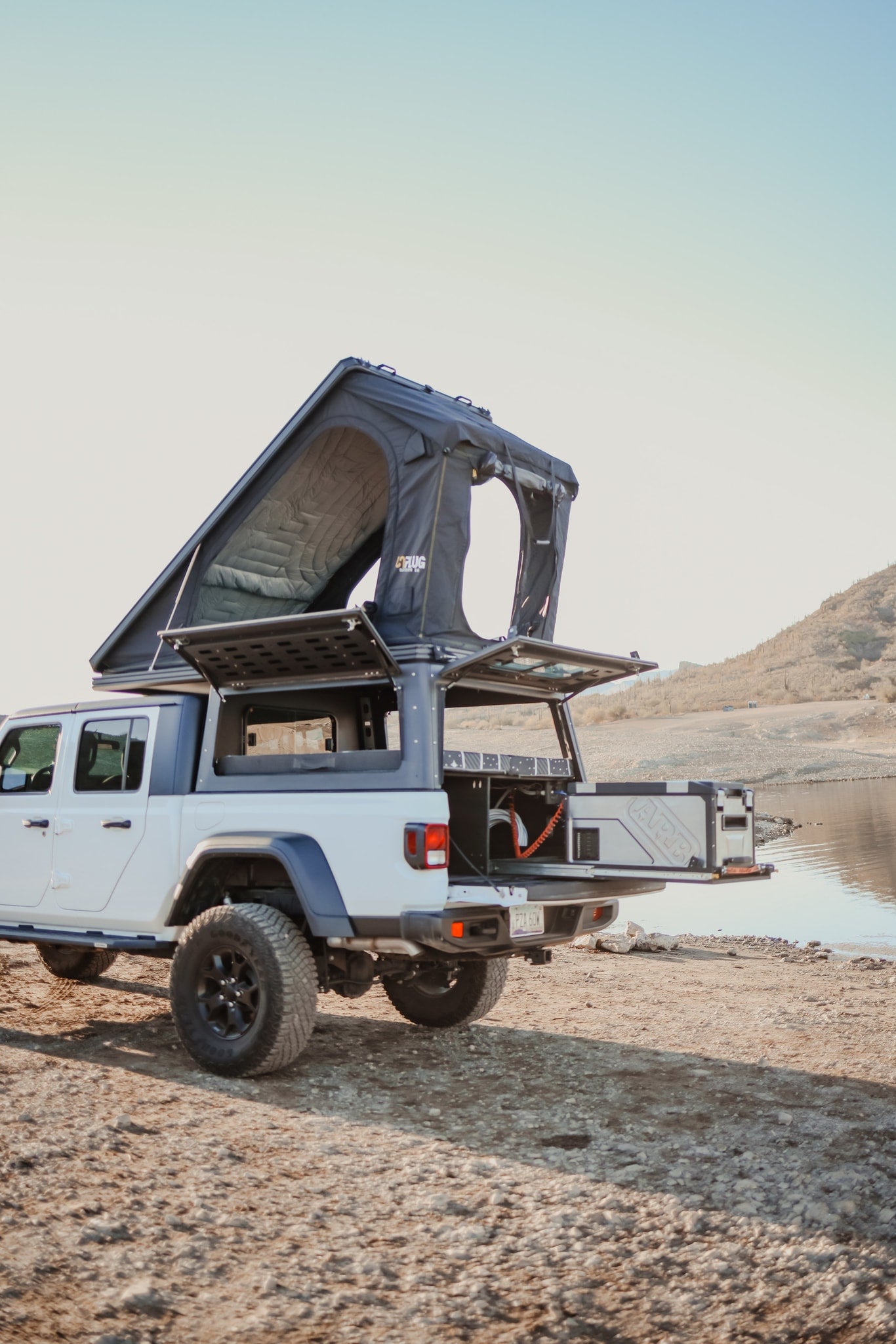 White Jeep Gladiator overland rig with a pop-up roof tent & pull-out fridge, ideal for an RV rental adventure by the lake. — photo 19