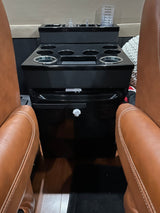 RV rental: Plush leather seats flank a black console with cup holders, storage, and a mini-fridge for ultimate comfort.