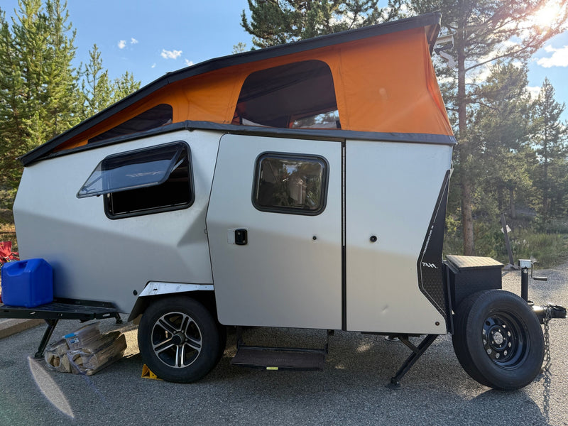 RV rental: Modern Taxa camper trailer with an orange pop-top tent and open window, ready for outdoor camping. — photo 2